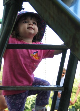 Isabella climbs the ladder to the slide
