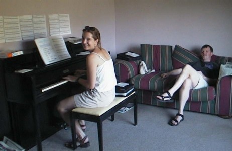 Valerie playing my piano while Chris watches (in August 2000)